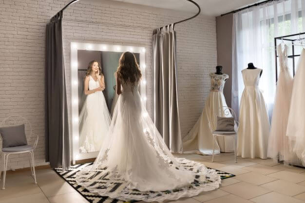 a bride to be tries out wedding dresses