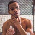 man applies aftershave