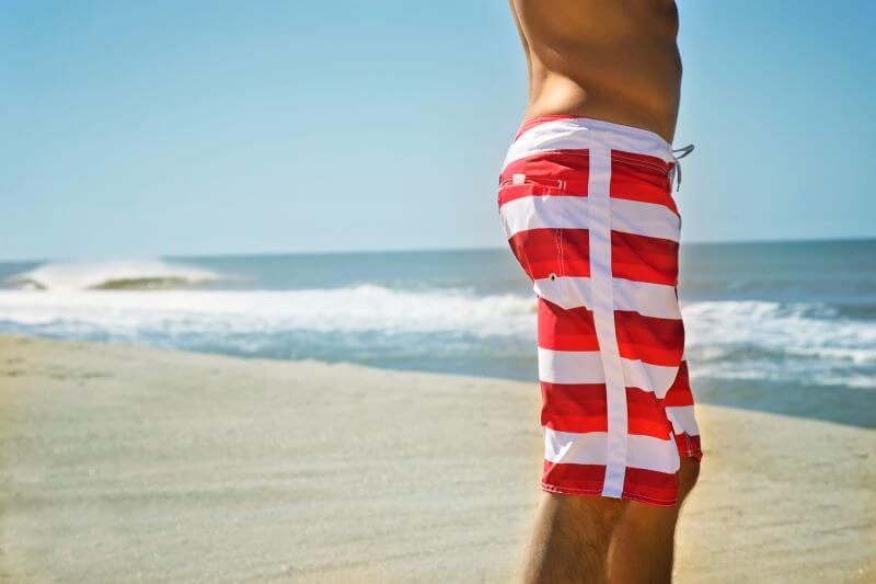 man in board shorts at the beach