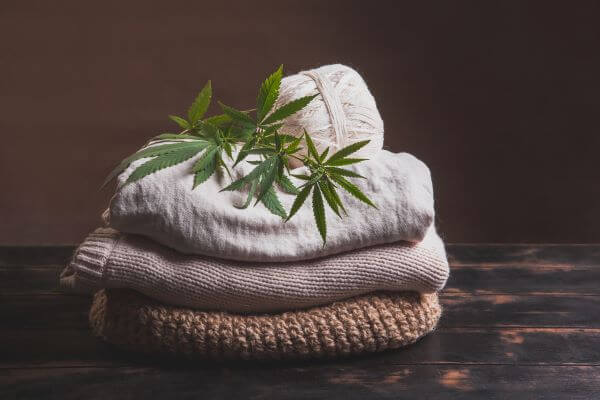 Hemp clothing in a pile with cannabis leaf on top