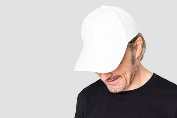 Man in white baseball cap pulled down over the eyes
